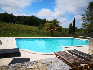 a large swimming pool with blue water and a patio at "Villa spacieuse à Sigoulès avec piscine privée" in Sigoulès