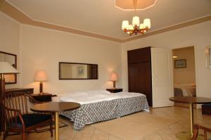 ギェネシュディアーシュにあるCastelinho Apartmanházのベッドルーム1室(ベッド1台、テーブル2台、椅子付)