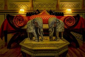 a statue of two elephants in front of a bed at The Umaid Vilas Royal Heritage Haveli in Jaipur