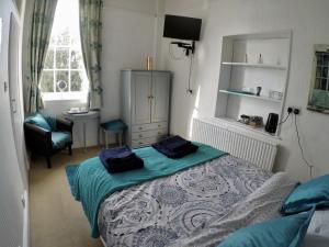 um quarto com uma cama, uma cadeira e uma janela em Whitchurch Farm Guesthouse em Alderminster