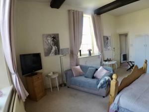 a living room with a couch and a tv at Whitchurch Farm Guesthouse in Alderminster