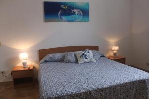 ein Schlafzimmer mit einem Bett und zwei Lampen an Tischen in der Unterkunft Le Case Dei pescatori - Il Varo in Ponza