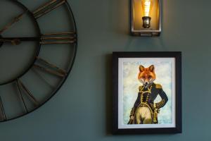 una imagen de un zorro vestido con armadura en una pared con un reloj en Coach House Inn, en Dorchester