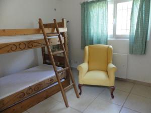 een slaapkamer met een stapelbed en een gele stoel bij Maisonnette au calme et proche mer in Mandelieu-la-Napoule
