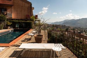 uma varanda com uma piscina, uma mesa e cadeiras em BnB Casa Rossa em Monreale