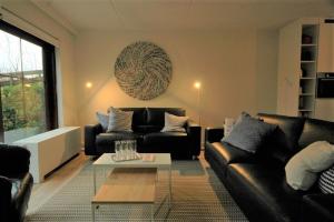 a living room with two black couches and a table at Dune in Retranchement