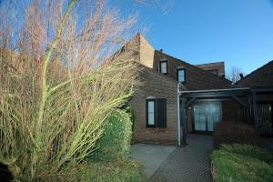 a brick house with a tree in front of it at Dune in Retranchement