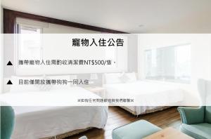 a white bedroom with two beds and a chair at Gu-Ji Gu-Ji Garden B&B in Luodong