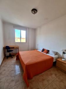 1 dormitorio con cama, escritorio y ventana en apartemento ideal grupo y familia climatisacion y cerca playa . mongrell, en Valencia