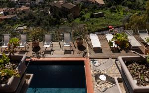 a patio area with chairs, tables, and a pool at Casa Rossa in Monreale