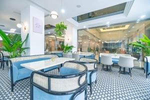 a restaurant with blue and white chairs and tables at Bao Son International Hotel in Hanoi +131 photos