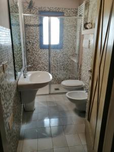 ein Badezimmer mit zwei Waschbecken, einer Dusche und einem WC in der Unterkunft Subretia Residenze Di Campagna in Montefalco