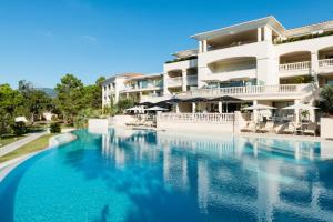 a swimming pool in front of a hotel at Hotel Don Cesar in Porto-Vecchio