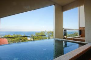 a swimming pool with a view of the ocean at Awaji Hamarikyu in Minamiawaji