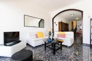 sala de estar con 2 sofás blancos y TV en Vista Mejía 1, en Caleta de Caballo