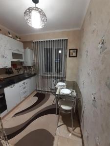 a kitchen with a desk and a table in it at Двокімнатна in Shepetivka