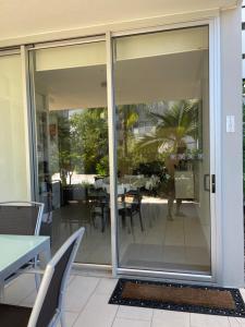 una puerta corredera de cristal que conduce a un patio con mesa en Euodia Unit 1102, en Nelly Bay