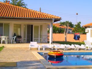 una casa con una piscina con un barco rojo. en Вили Брендън и Дезмънд - до Балчик - Brendon and Desmond Villas - near Balchik, en Sokolovo