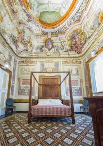 Villa Signorini Hotel في إيركولانو: غرفة نوم بسرير وسقف مع لوحات