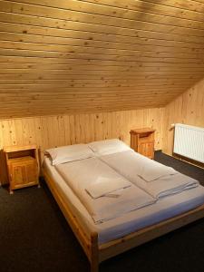 ein Schlafzimmer mit einem Bett in einem Holzzimmer in der Unterkunft Freemont in Braşov