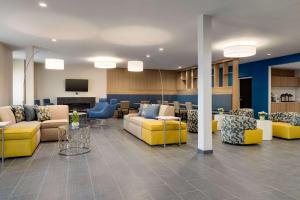 a lobby with couches and chairs and a television at Microtel Inn & Suites by Wyndham Gambrills in Odenton