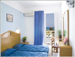 a bedroom with a bed and a desk and a window at Asterias Bay-Theologos in Theologos