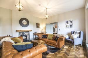 a living room with leather furniture and a fireplace at Cilrhiw Country House - Princes Gate in Narberth