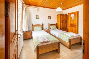 two beds in a room with wooden floors at İznik Seyir Otel in İznik