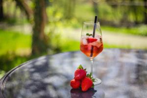 ein Glas Wein und Erdbeeren auf dem Tisch in der Unterkunft DasSchaffers - MeinWohlfühlhotel in Bad Mergentheim