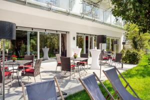 un patio con un montón de sillas y mesas en DasSchaffers - MeinWohlfühlhotel, en Bad Mergentheim