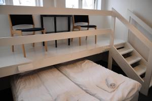a bunk bed with two chairs in a room at Den Gamle Arrest in Ribe