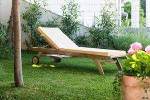 un banc en bois assis sur l'herbe dans une cour dans l'établissement Apartments Gaura, à Dubrovnik