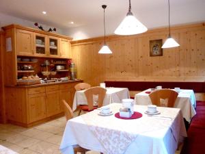 a dining room with two tables and a kitchen at Garni Siebnerhof in San Candido