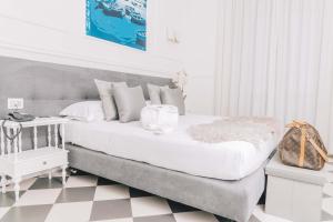 a white bedroom with a large bed and a table at Hotel Stabia in Castellammare di Stabia