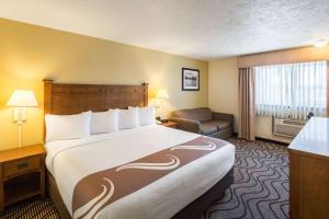 a hotel room with a large bed and a chair at Quality Inn & Suites Coeur d'Alene in Coeur d'Alene