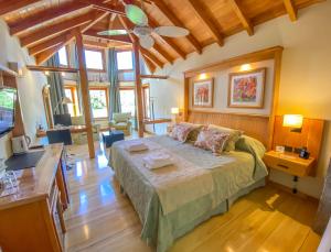 um quarto com uma cama grande num quarto em Hotel y Cabañas Le Village em San Martín de los Andes