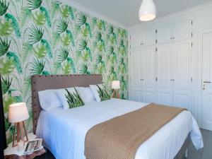 a bedroom with a bed with a tropical wallpaper at Amazónico Playa de Mogán in Puerto de Mogán