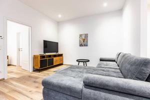 a living room with a couch and a flat screen tv at Modern apartment next to subway station in Vienna