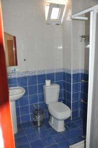 a blue tiled bathroom with a toilet and a sink at BASILS APART HOTEL in Marmaris
