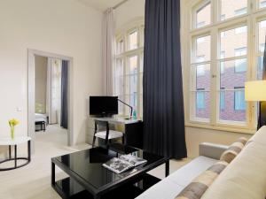 uma sala de estar com um sofá e uma mesa em H10 Ku'damm Lofts em Berlim