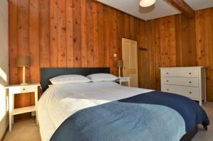 a bedroom with a bed and wooden walls at Scallopshell Lodge in Otter Ferry