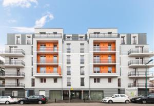 un edificio blanco con coches estacionados frente a él en Aparthotel Adagio Access Saint Louis Bâle, en Saint-Louis