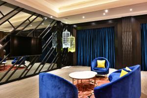 a living room with blue chairs and a tv at Venice Motel in Taichung