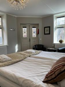 a large white bed in a bedroom with a chandelier at Börsen Annex in Visby +17 photos