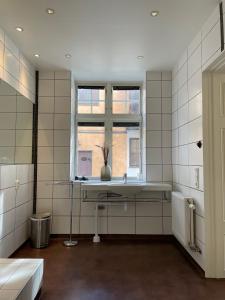 La salle de bains blanche est pourvue d'une fenêtre et d'un lavabo. dans l'établissement Börsen Annex, à Visby