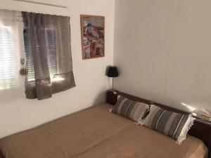 - un lit dans une chambre avec fenêtre dans l'établissement Kokos Traditional Family House, à Cap Sounion