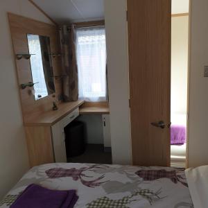 a bedroom with a bed and a desk and a window at Deer lodge in Auchterarder