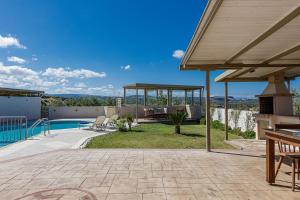 a patio with a pool and a gazebo at Dina & Pelagia Villas, Serene Country Escapes, By ThinkVilla in Roumelí
