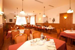 Gasthof zum Bären في Bühlertann: مطعم فيه طاولات وكراسي في الغرفة