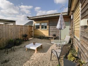 eine Terrasse mit einem Tisch und Stühlen sowie ein Gebäude in der Unterkunft Tiny Willow in Blandford Forum